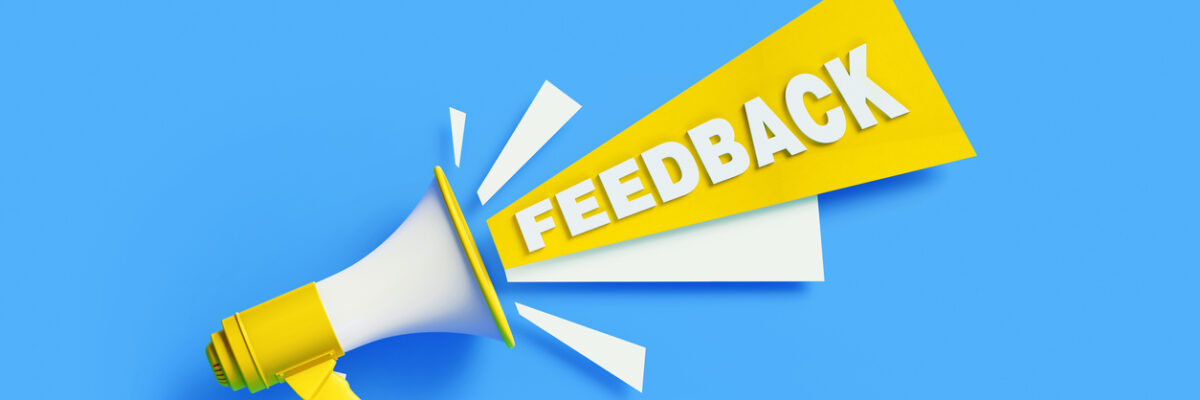 Feedback coming out from a yellow megaphone on blue background. Horizontal composition with copy space. Great use for survey and feedback concepts.
